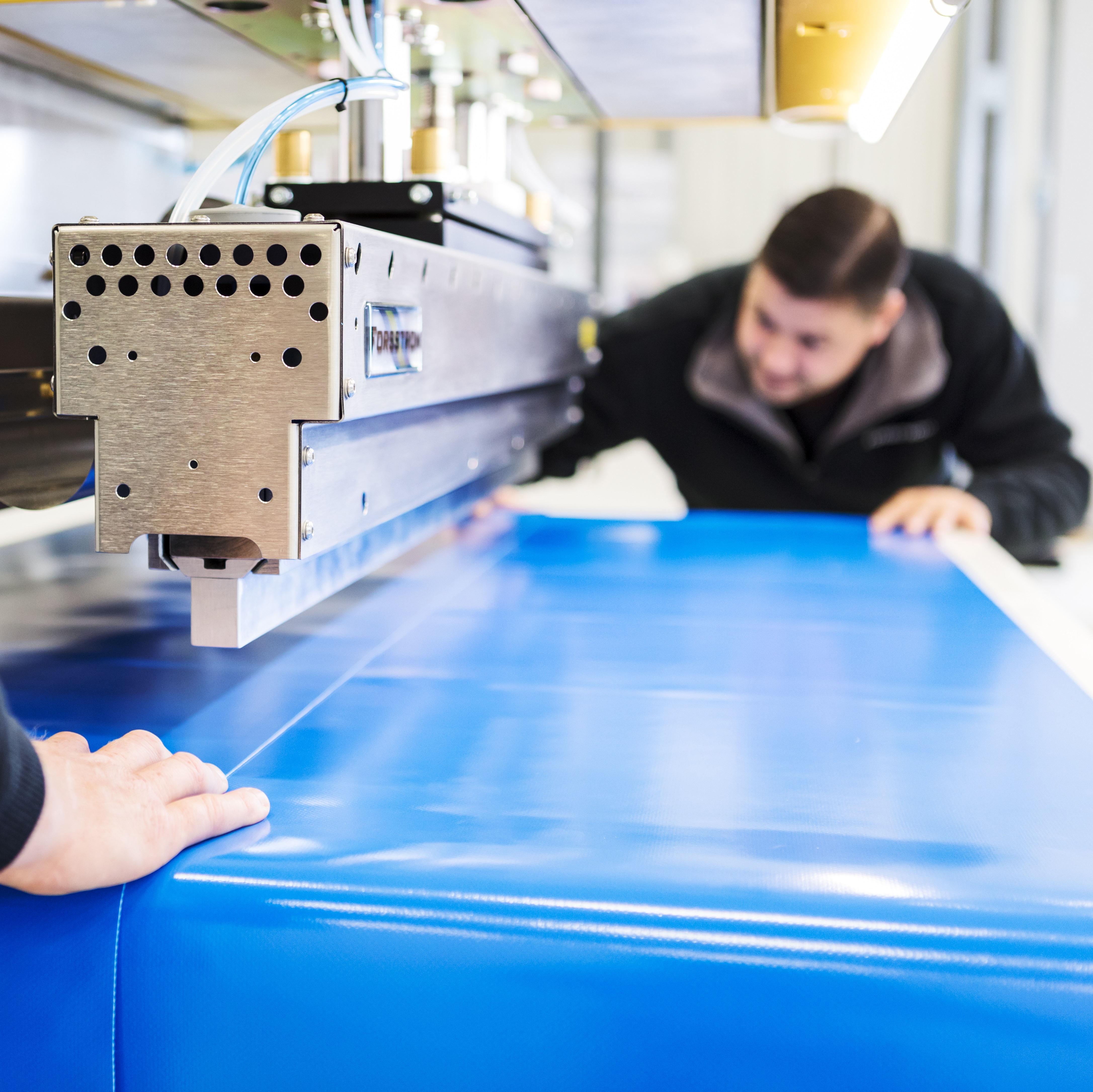 This is a photo showing two of our technicians test welding in a Forsstrom machine.